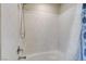 A clean shower/tub combo area with a marbled interior and a detachable shower head and modern fixtures at 6618 Tangled Vines Ave, Las Vegas, NV 89139