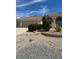 Inviting home showcasing a attached garage, desert landscape and arched entryway, seamlessly blending curb appeal and functionality at 6841 Longmeadow Dr, Pahrump, NV 89061