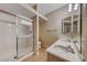 Well-lit bathroom with a double sink vanity, framed mirrors, and a tiled shower with glass doors at 6916 Dorita Ave # 102, Las Vegas, NV 89108