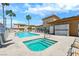 Community pool and hot tub surrounded by lounge chairs, showers, and palm trees at 6916 Dorita Ave # 102, Las Vegas, NV 89108