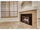 Close-up of a modern fireplace with an elegant mantle, surrounded by tile flooring and a window with blinds at 6916 Dorita Ave # 102, Las Vegas, NV 89108