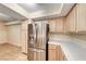 Kitchen boasting stainless steel refrigerator, neutral cabinets, tile countertops, and a bright, open layout at 6916 Dorita Ave # 102, Las Vegas, NV 89108