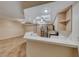 Open kitchen connecting to a living area, featuring stainless steel appliances, tile countertops, and a functional layout at 6916 Dorita Ave # 102, Las Vegas, NV 89108