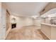 Open-concept living room and kitchen featuring tile flooring, stainless steel appliances, and a fireplace at 6916 Dorita Ave # 102, Las Vegas, NV 89108