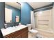 Blue bathroom with modern vanity, dark faucet, and a shower-tub combination with a striped shower curtain at 711 Sari Dr, Las Vegas, NV 89110