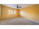 Carpeted bedroom featuring a window, neutral walls, and a ceiling fan at 711 Sari Dr, Las Vegas, NV 89110