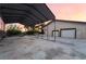 View of long carport with direct access to a three-car garage with a colorful sunset backdrop at 711 Sari Dr, Las Vegas, NV 89110