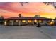 Expansive single story home boasts arched entryways and a water fountain, set against a vibrant sunset sky at 711 Sari Dr, Las Vegas, NV 89110