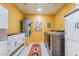 Well-lit laundry room with cabinets, washer, dryer, and a decorative rug at 711 Sari Dr, Las Vegas, NV 89110