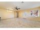 Open living room with neutral carpet, ceiling fan, and natural light at 711 Sari Dr, Las Vegas, NV 89110