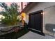 Exterior view of a tiled patio with an artificial turf lawn, seating, and a large double door at 711 Sari Dr, Las Vegas, NV 89110