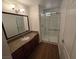 Bathroom with granite vanity, frameless shower, wood-look flooring, and modern fixtures at 7200 Pirates Cove Rd # 2025, Las Vegas, NV 89145