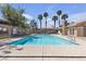 Community pool surrounded by lush trees and tropical palm trees at 7200 Pirates Cove Rd # 2025, Las Vegas, NV 89145