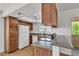 Well-lit kitchen features wood cabinets, stone countertops, white appliances, and a breakfast bar at 7200 Pirates Cove Rd # 2025, Las Vegas, NV 89145