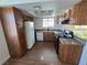 Updated kitchen featuring brown cabinets, granite countertops, and black appliances at 7200 Pirates Cove Rd # 2025, Las Vegas, NV 89145