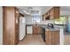 Well-lit kitchen features wood cabinets, stone countertops, white appliances, and laminate wood flooring at 7200 Pirates Cove Rd # 2025, Las Vegas, NV 89145