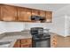 Kitchen with stone countertops, wooden cabinetry, range oven and breakfast bar at 7200 Pirates Cove Rd # 2025, Las Vegas, NV 89145