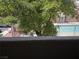 Community pool view framed by lush tree at 7200 Pirates Cove Rd # 2025, Las Vegas, NV 89145
