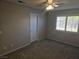 This bedroom has neutral colored walls, gray carpet and a ceiling fan at 734 Rusty Spur Dr, Henderson, NV 89014