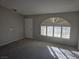 Sun-drenched living room featuring neutral walls, plush carpeting, and arched windows with plantation shutters at 734 Rusty Spur Dr, Henderson, NV 89014