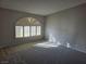 Bright living room featuring neutral walls, plush carpeting, and arched windows with plantation shutters at 734 Rusty Spur Dr, Henderson, NV 89014
