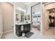 This beautiful bathroom offers double sinks, large mirror, modern lighting and a view into the primary bedroom at 7473 Deschutes Cir, Las Vegas, NV 89129