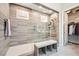 Spacious tiled shower with glass door, seating and a view of the walk-in closet at 7473 Deschutes Cir, Las Vegas, NV 89129