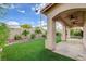 Relaxing backyard with a covered patio, artificial turf, and manicured landscaping at 7709 Sierra Paseo Ln, Las Vegas, NV 89128