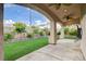 Covered patio overlooking a green artificial turf lawn and beautiful landscaping at 7709 Sierra Paseo Ln, Las Vegas, NV 89128