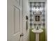 Charming half bathroom features buffalo check wallpaper and pedestal sink at 7709 Sierra Paseo Ln, Las Vegas, NV 89128