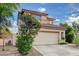 Two-story stucco home with a tile roof, a two-car garage, and green landscaping at 7709 Sierra Paseo Ln, Las Vegas, NV 89128