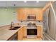 Stylish kitchen with stainless steel appliances, including a gas range, light wood cabinets, and granite countertop at 7709 Sierra Paseo Ln, Las Vegas, NV 89128