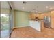 Kitchen with stainless steel appliances, wood cabinets, granite countertops, and wood-look tile flooring at 7709 Sierra Paseo Ln, Las Vegas, NV 89128