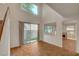 Bright living room featuring wood floors, soaring ceilings, and sliding glass doors to backyard at 7709 Sierra Paseo Ln, Las Vegas, NV 89128