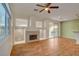 Open living space with wood floors, a ceiling fan, stone fireplace, and backyard access at 7709 Sierra Paseo Ln, Las Vegas, NV 89128
