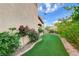 Side yard with a garden bed and artificial grass at 7709 Sierra Paseo Ln, Las Vegas, NV 89128