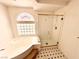 A bathtub and separate glass enclosed shower stall in a bathroom with tiled flooring and a large window at 7851 Tidal Pool Ct, Las Vegas, NV 89139