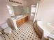 A view of the bathroom with double sinks, a tub, a toilet and black and white tiled flooring at 7851 Tidal Pool Ct, Las Vegas, NV 89139