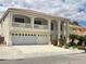 Elegant two-story house showcasing a balcony, arched windows, three-car garage, and tasteful landscaping at 7851 Tidal Pool Ct, Las Vegas, NV 89139
