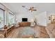 Spacious living room with hardwood floors, ceiling fan, and large windows with natural light at 7908 House Sparrow St, North Las Vegas, NV 89084