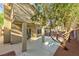 Covered patio and mature tree landscape in a private backyard setting with secure fencing at 8113 Bay Springs Dr, Las Vegas, NV 89128