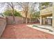 Fenced backyard with a mix of trees, low-maintenance ground cover, and a covered patio area at 8113 Bay Springs Dr, Las Vegas, NV 89128