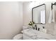 Updated half bathroom with modern fixtures, marble countertop and square mirror at 8113 Bay Springs Dr, Las Vegas, NV 89128