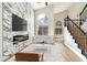 Elegant living room with fireplace, high ceilings, large windows, and modern staircase at 8113 Bay Springs Dr, Las Vegas, NV 89128