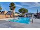 Community pool with lounge chairs, palm trees, and surrounding landscaping at 8113 Bay Springs Dr, Las Vegas, NV 89128