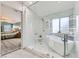 Modern bathroom features a soaking tub, walk-in shower with a glass door, and tile floors at 8217 Fritzen Ave, Las Vegas, NV 89131