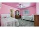 Pink bedroom featuring two beds, neutral carpet, and a vintage dresser with a mirror at 8217 Fritzen Ave, Las Vegas, NV 89131