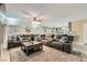 Spacious living area with a large sectional sofa, ceiling fan, and a view into the adjacent kitchen at 8217 Fritzen Ave, Las Vegas, NV 89131