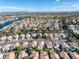 Picturesque aerial view of homes nestled in a vibrant community with lush greenery and serene lake views at 8228 Lauderdale Ct, Las Vegas, NV 89128