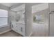 Modern bathroom featuring dual vanity sinks with white cabinets and a view to the yard at 8228 Lauderdale Ct, Las Vegas, NV 89128